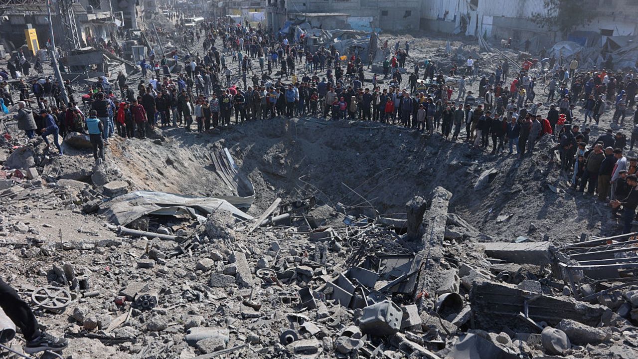 Palestinians gather around a large crater following an Israeli strike on a metalsmith workshop at the Zaytoun neighbouhood in Gaza City on April 13, 2025. (Photo by Omar AL-QATTAA / AFP) (Photo by OMAR AL-QATTAA/AFP via Getty Images)          