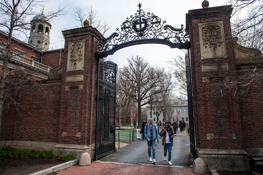 People walk through a gate as they exit Harvard Yard on the campus of Harvard University campus in Cambridge, Massachusetts, in April.
