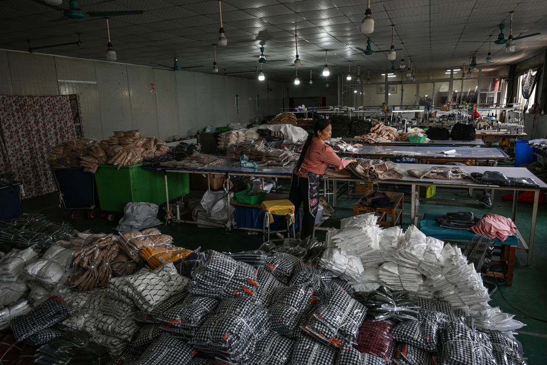 An employee packages garments for the online Chinese e-commerce company Temu at a clothing factory in Guangzhou, China.