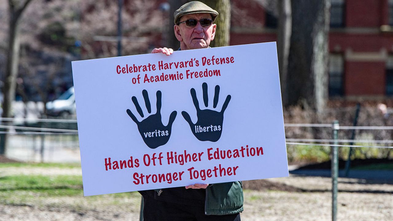 A Harvard Faculty member holds a sign as he exits Harvard Yard after a rally was held against President Donald Trump's attacks on Harvard University at Harvard University in Cambridge, Massachusetts on April 17, 2025. US President Donald Trump called Harvard a "joke" on April 16.2025, and said it should lose its government research contracts after the prestigious university refused demands that it accept outside political supervision. The Department of Homeland Security (DHS) also canceled $2.7 million worth of research grants to Harvard on Wednesday and threatened the university's ability to enroll international students unless it turns over records on visa-holders' "illegal and violent activities." (Photo by Joseph Prezioso / AFP) (Photo by JOSEPH PREZIOSO/AFP via Getty Images)          