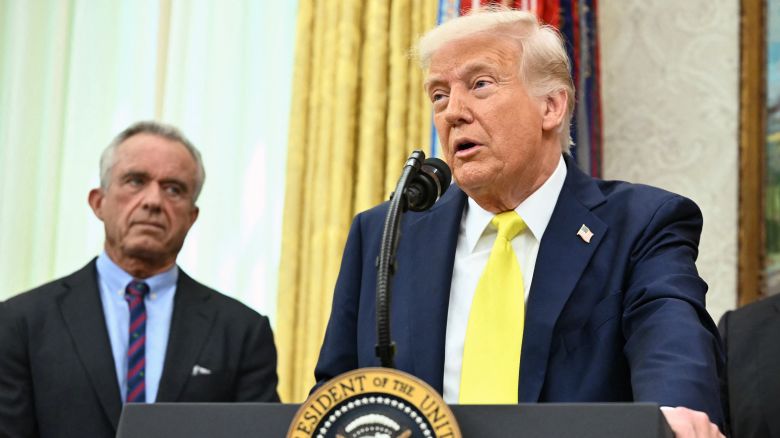 US President Donald Trump speaks as Health and Human Services Secretary Robert F. Kennedy Jr. looks on in the Oval Office on April 18, 2025.