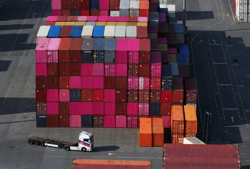 A truck is pictured driving among shipping containers in Hamburg Port in April 2025 in Hamburg, Germany.
