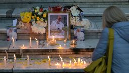Fieles dejan velas encendidas junto a un retrato del difunto papa Francisco en la entrada de la Catedral de Buenos Aires el 21 de abril de 2025.