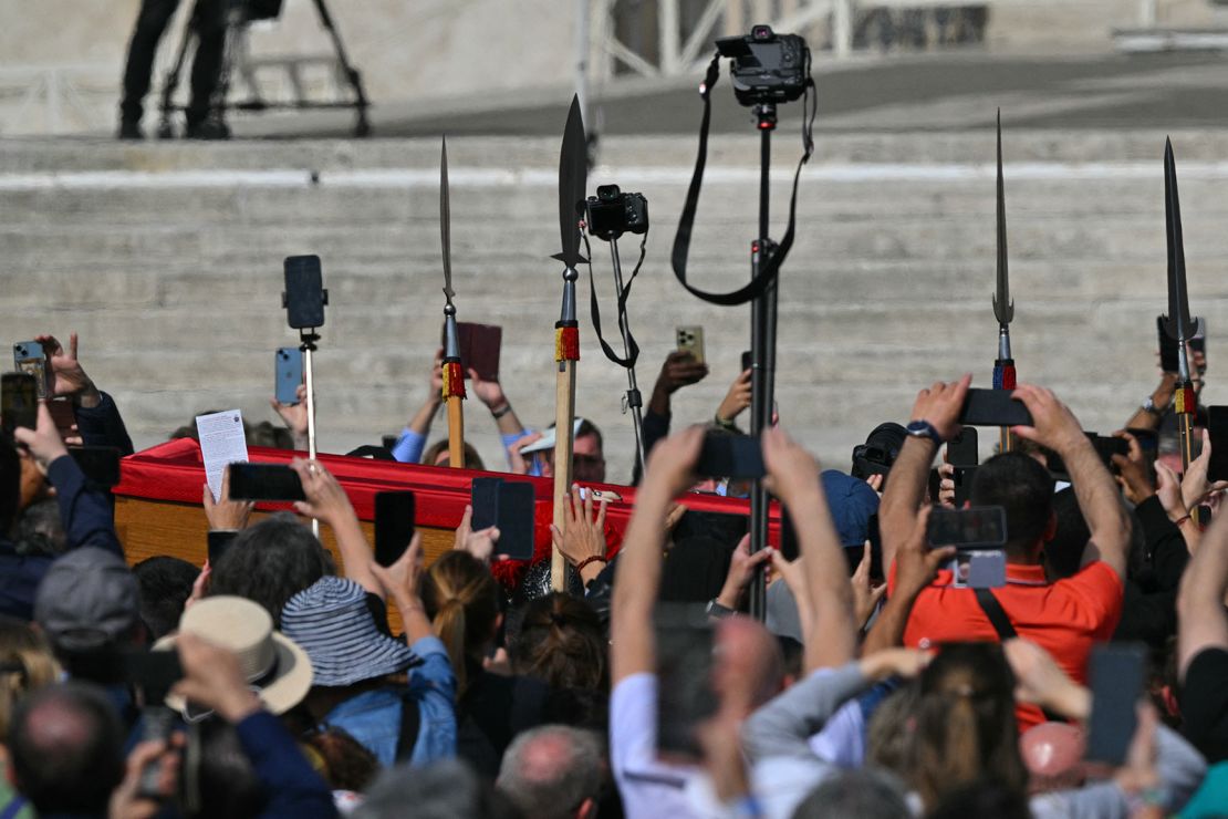Attendees use smartphones on St Peter's Square as the coffin of the late Pope Francis is transported in a from the chapel of Santa Marta to St Peter's Basilica in the Vatican on April 23, 2025.