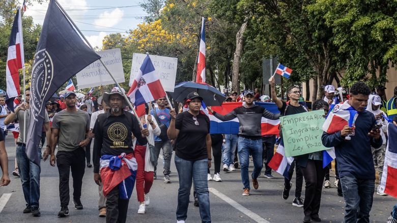 Simpatizantes del grupo nacionalista 'Antigua Orden Dominicana' ondean banderas de la República Dominicana mientras participan en una marcha contra la inmigración haitiana en Santo Domingo el 24 de abril de 2025.