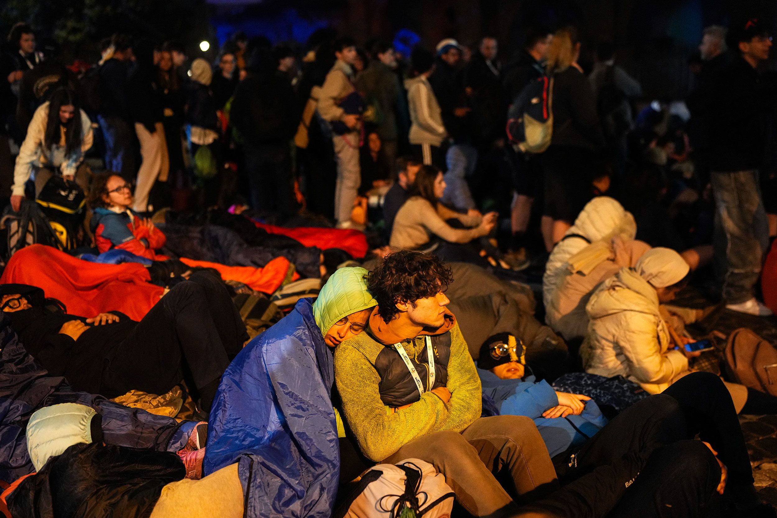 People rest on a street near the Vatican ahead of the funeral.