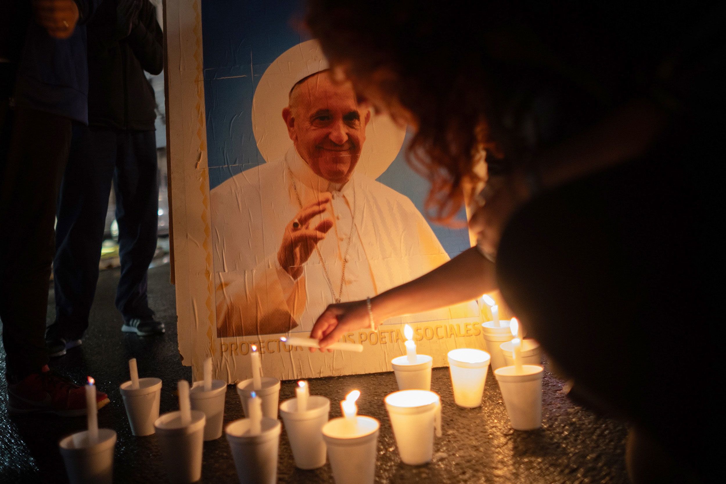 Mourners light candles next to an image of Pope Francis outside the Buenos Aires Cathedral in Argentina on Saturday.