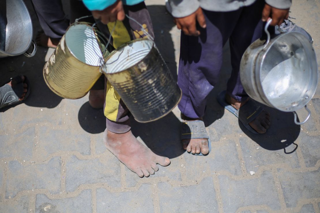 Niños palestinos hacen fila para recibir una comida caliente en un comedor social del Programa Mundial de Alimentos (PMA) de las Naciones Unidas en el campo de refugiados de Nuseirat, en el centro de Gaza, el 26 de abril de 2025.