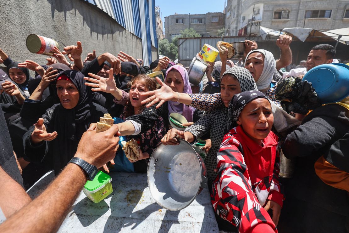 Palestinos hacen fila para recibir una comida caliente el 26 de abril de 2025.