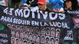 Familiares y estudiantes de la escuela rural de Ayotzinapa sostienen una pancarta mientras marchan durante una protesta para exigir al gobierno el esclarecimiento de los casos de los 43 estudiantes desaparecidos en Ciudad de México el 26 de abril de 2025.