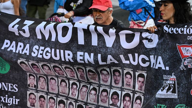 Familiares y estudiantes de la escuela rural de Ayotzinapa sostienen una pancarta mientras marchan durante una protesta para exigir al gobierno el esclarecimiento de los casos de los 43 estudiantes desaparecidos en Ciudad de México el 26 de abril de 2025.