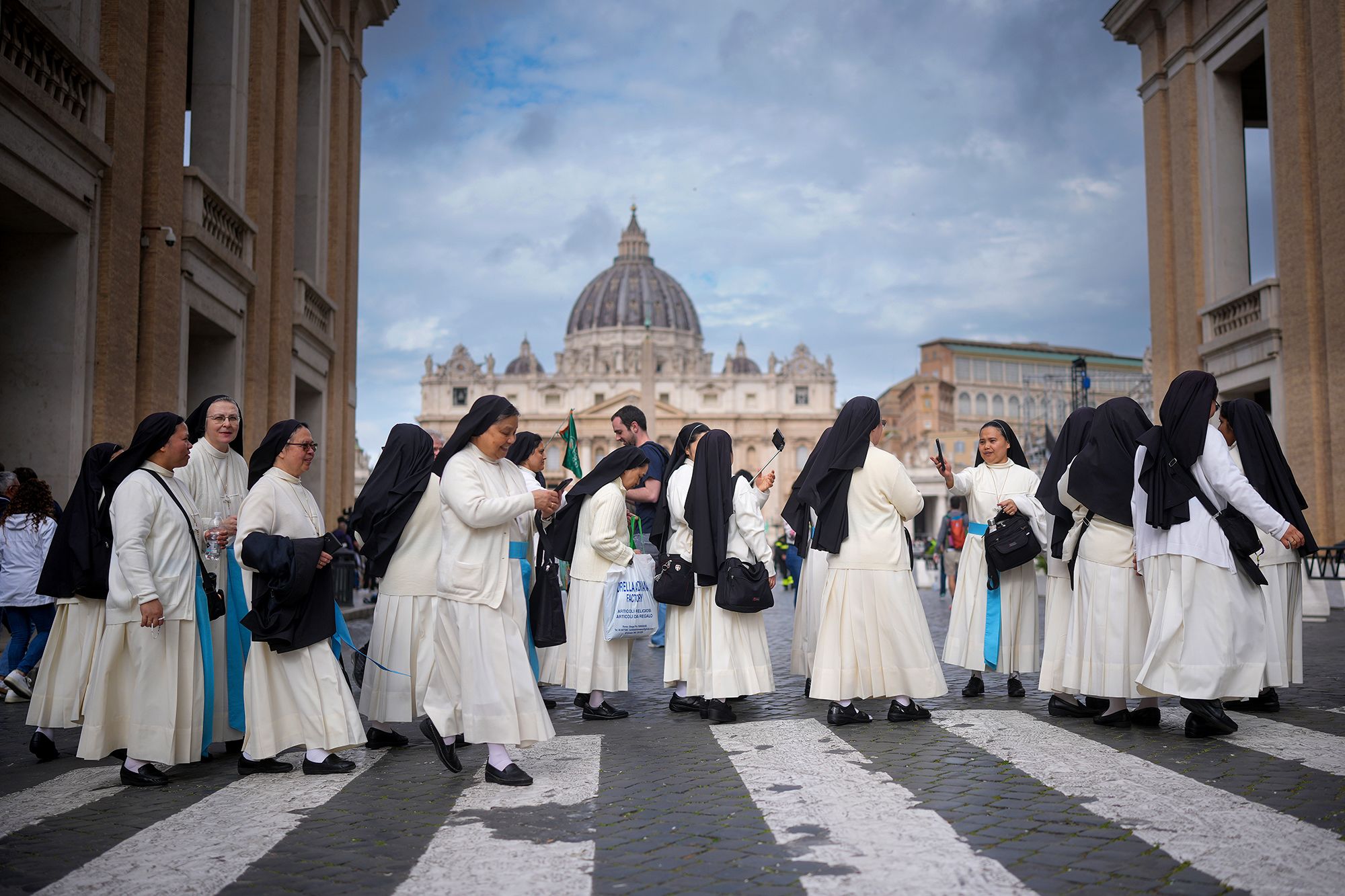 Nuns take selfies as they make their way to the line to view the pope on Thursday.