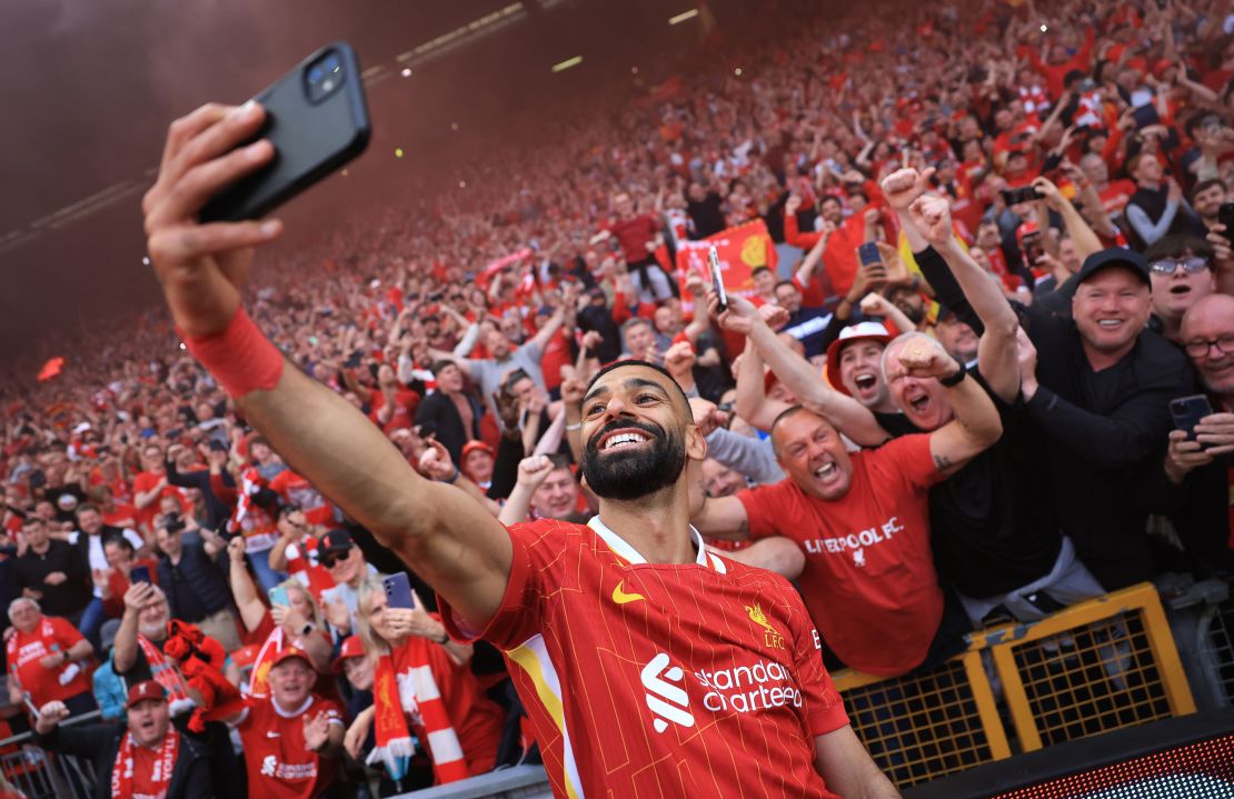 Mohamed Salah del Liverpool se toma una selfi con la afición, que celebra la victoria del equipo y la confirmación del título de la Premier League tras el partido entre el Liverpool FC y el Tottenham Hotspur FC en Anfield el 27 de abril de 2025 en Liverpool, Inglaterra.