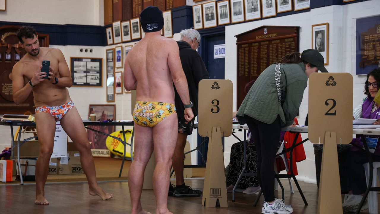 A man takes a photo of a fellow voter as they prepare to vote in the general election at a polling centre in the Bondi Surf Bathers Life Saving Club in Sydney on Saturday.