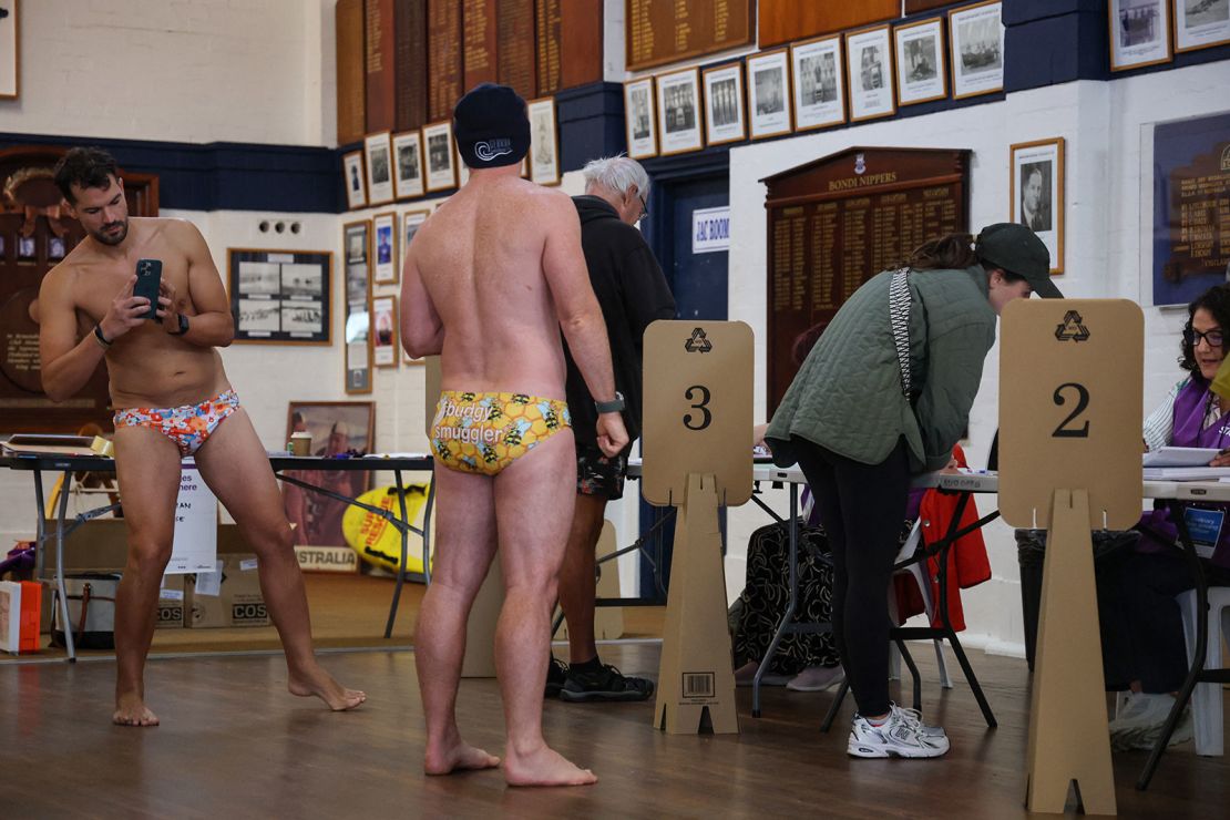 A man takes a photo of a fellow voter as they prepare to vote in the general election at a polling centre in the Bondi Surf Bathers Life Saving Club in Sydney on Saturday.