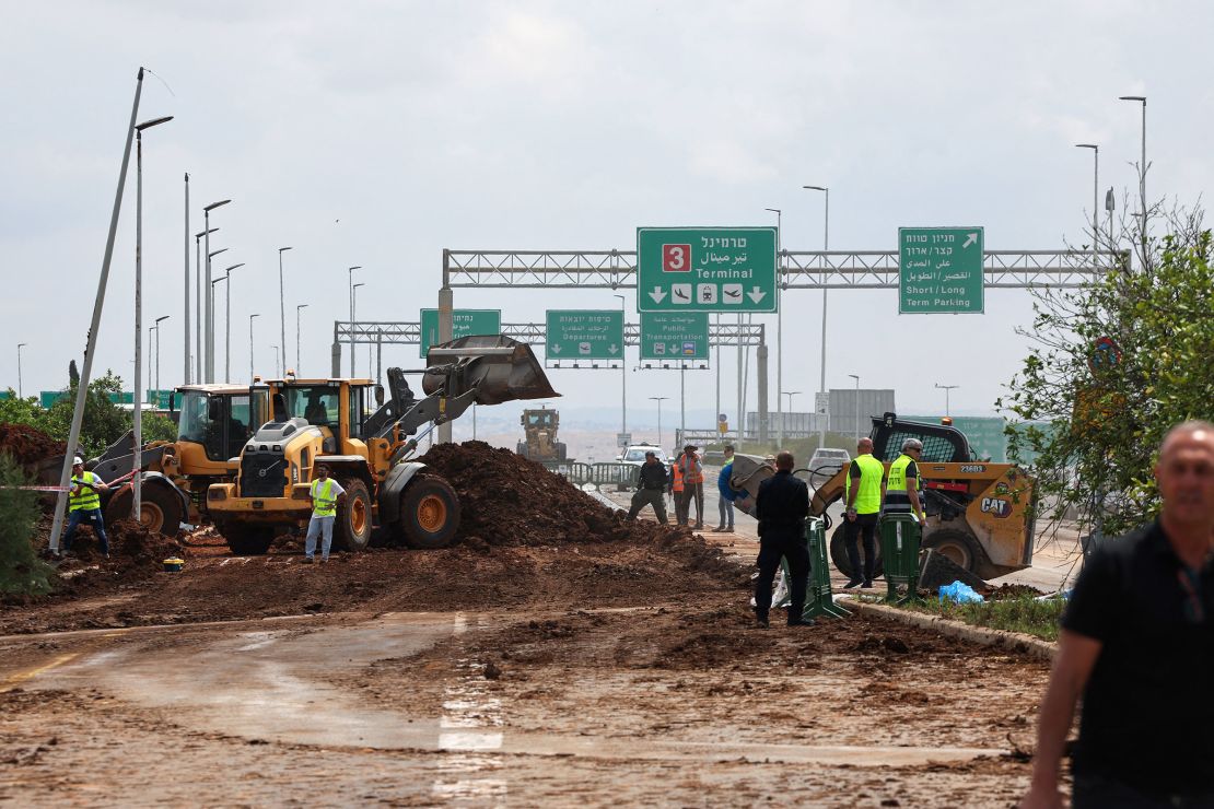 Israeli emergency services clear debris from a road outside Ben Gurion Airport.