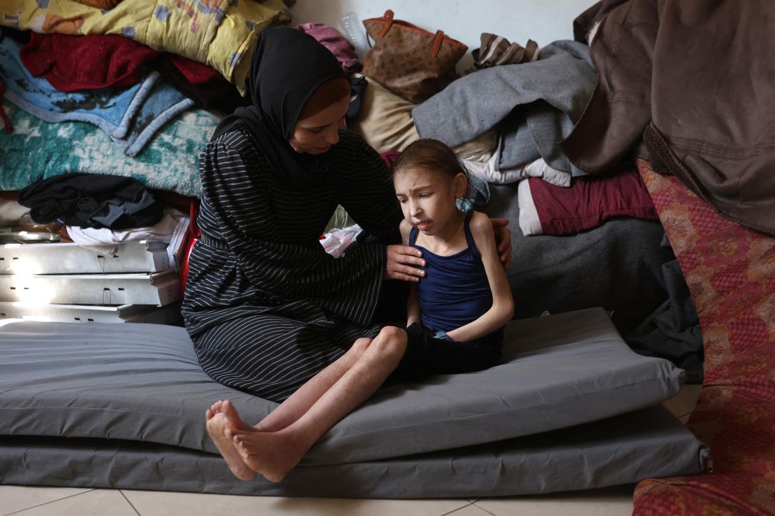 Shuruq Ayyad consoles her 12-year-old daughter Rahaf, who is suffering from malnutrition, at a school-turned-shelter in al-Rimal in central Gaza City on May 4.