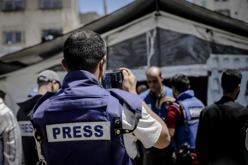 A man wearing a press vest films the World Press Freedom Day demonstration in Gaza City on May 4, 2025.