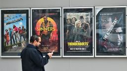 A man walks past movie posters at at AMC Theater in Montebello, California on May 5, 2025.