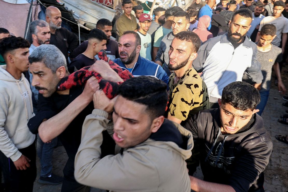 People carry a person who was injured in an Israeli strike on a school compound at the Bureij refugee camp in central Gaza on May 6, 2025.