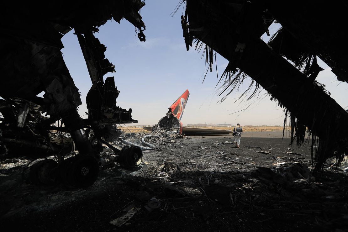 A Houthi rebel walks next to a destroyed plane at the Sanaa International Airport last month, after Israeli strikes on the rebel-held capital Sanaa.