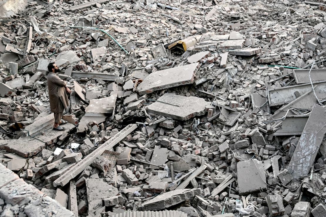 Locals stand on the debris of destroyed structures at the Government Health and Educational complex in Muridke about 30 kilometres from Lahore, on May 7, after Indian strikes.