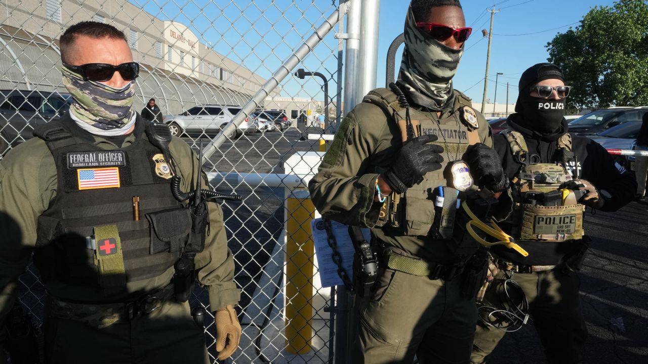 Immigration and Customs Enforcement (ICE) agents stand near a gate at Delaney Hall, a newly converted immigrant detention centre in Elizabeth, New Jersey May 7, 2025. Delaney Hall has the ability to hold over a 1000 people, and the detention facility, privately owned by The GEO Group, holds a contract with the federal government to house people arrested by ICE. (Photo by TIMOTHY A. CLARY / AFP) (Photo by TIMOTHY A. CLARY/AFP via Getty Images)          
