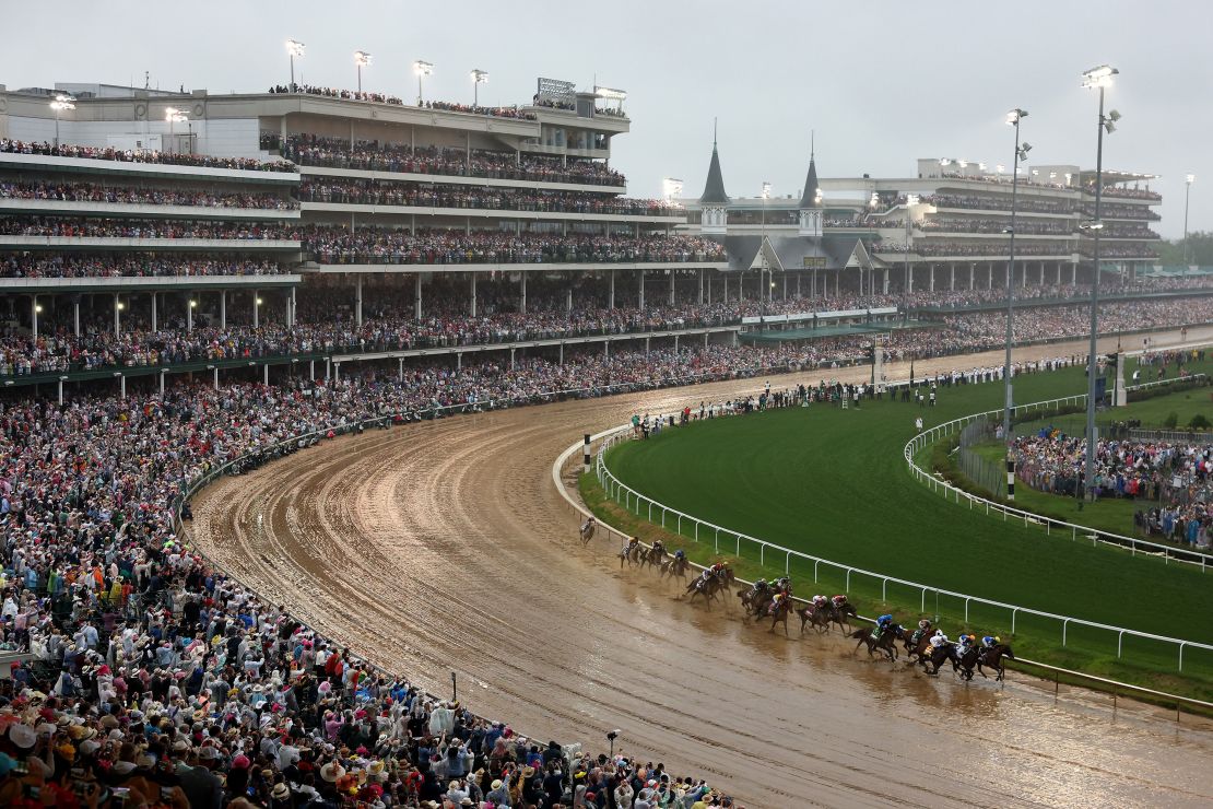 Horses race around turn one.