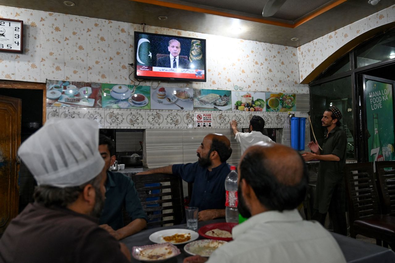 People watch as Pakistan's Prime Minister Shehbaz Sharif addresses the nation, in Islamabad, Pakistan, on Wednesday.
