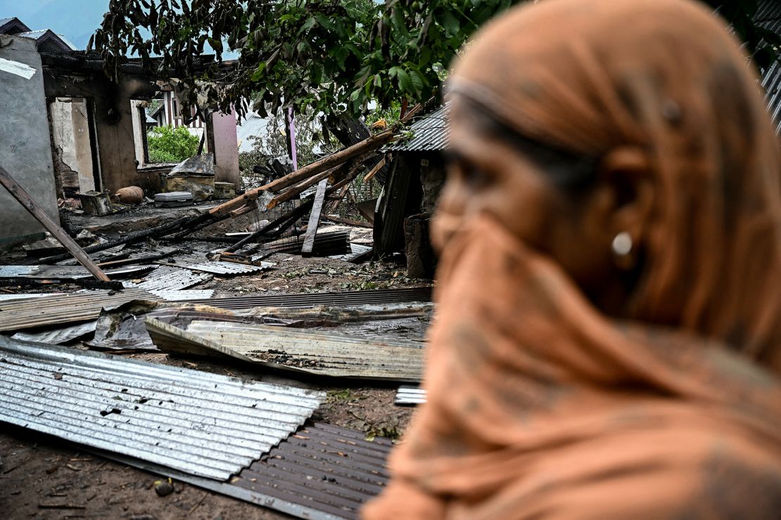 A woman stands outside a house destroyed by Pakistani artillery shelling at the Salamabad village in Uri, about 110kms from Srinagar, on May 8.