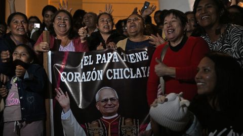 People pose next to the image of Robert Francis Prevost, who became Pope Leo XIV on May 8, 2025, in front of the cathedral of Chiclayo in northern Peru on the day of his election as the Catholic Church's 267th pontiff. The US-born pontiff, close to Pope Francis, became a Peruvian national in 2015 and devoted more than 20 years as a missionary in Peru. (Photo by ERNESTO BENAVIDES / AFP) (Photo by ERNESTO BENAVIDES/AFP via Getty Images)