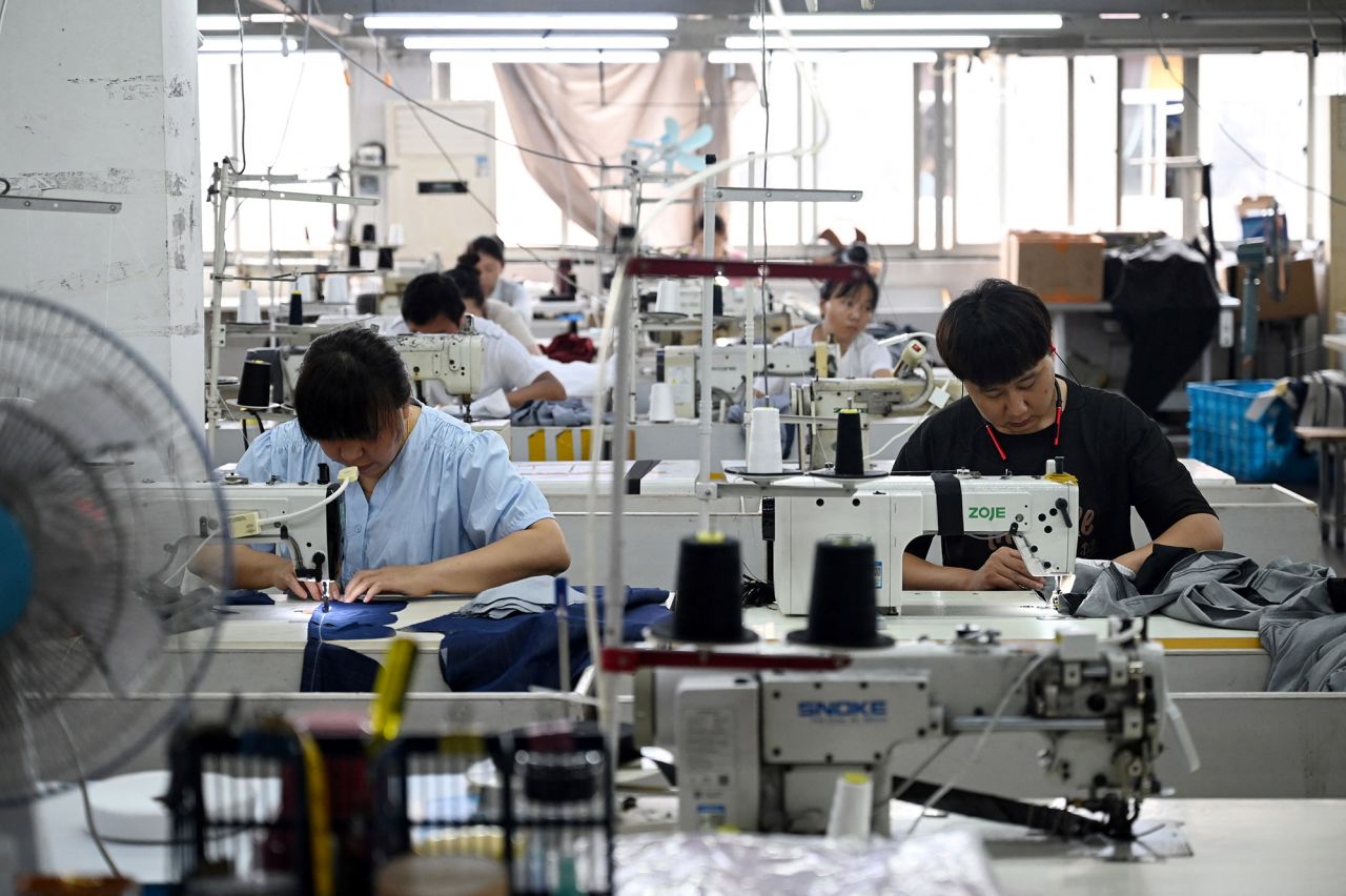 Workers sew clothing at a company in the textile industrial in Shaoxing, China, on Friday.