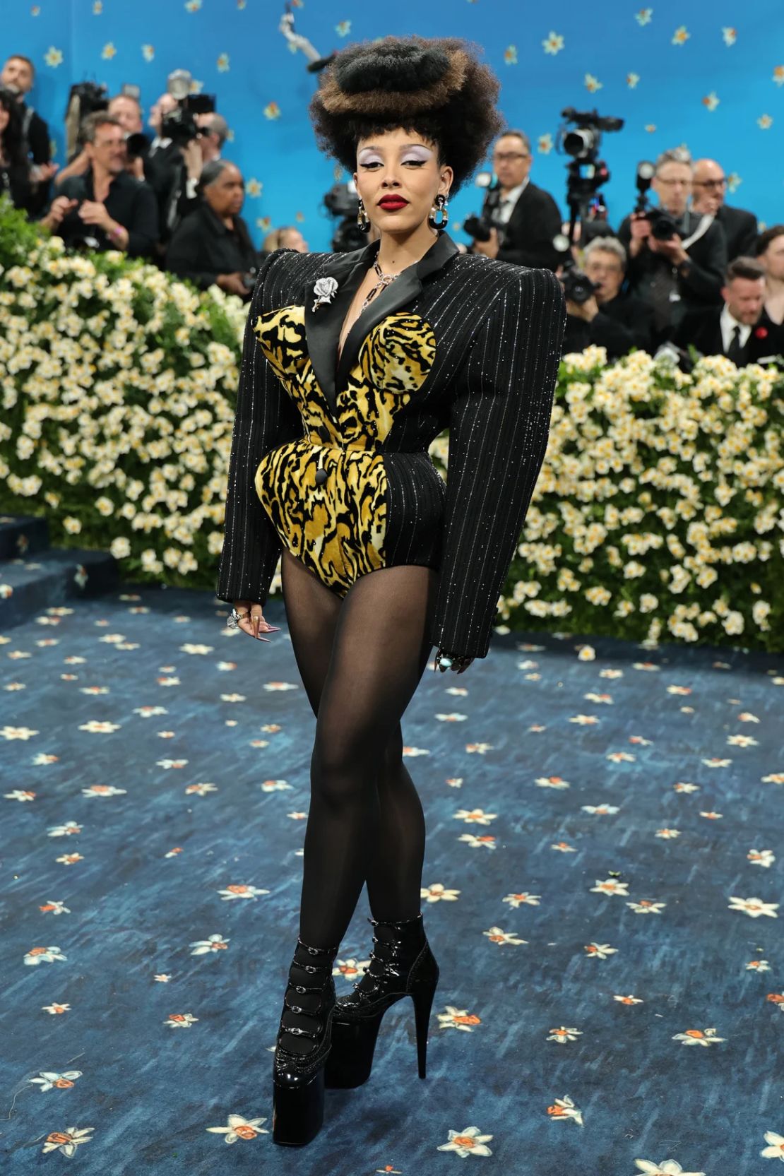 Doja Cat presenta el punk con su look personalizado de Marc Jacobs al estilo de los años 80 inspirado en "Madre África", dijo a los presentadores de la transmisión en vivo de la alfombra de la Met Gala de Vogue. Con las formas fuertes y exageradas ceñidas en la cintura, la artista se sintió como un gánster y la madame.