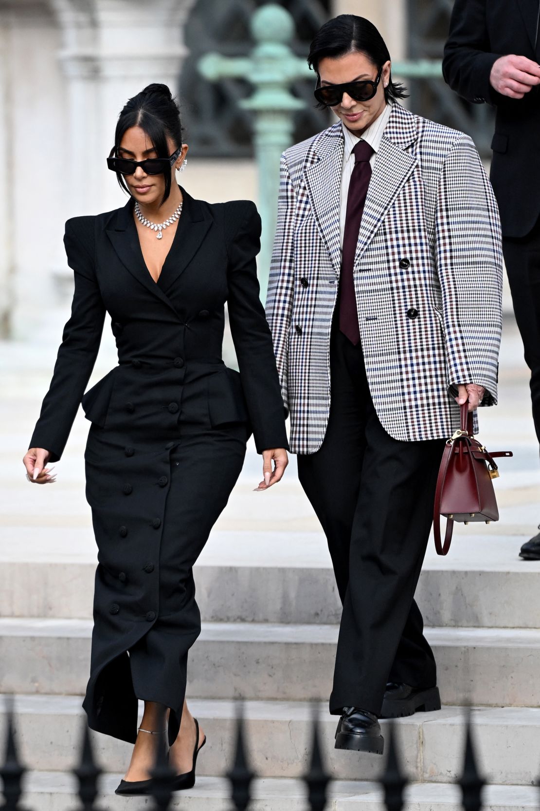 Accompanied by her mother Kris Jenner, Kardashian's diamond necklace and ear cuffs stood out against an all-black skirt-suit.