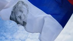 A flag of the Frente Amplio coallition with the face of late Uruguay's former President Jose 'Pepe' Mujica is pictured outside the Palacio Legislativo in Montevideo, on May 14, 2025, a day after his death. Mujica, an ex-guerrilla fighter and hero of the Latin American left, died on May 13, 2025 at the age of 89. The humble leader -- who once spent a dozen years behind bars for revolutionary activity -- lost his battle against cancer after announcing in January the disease had spread and he would stop treatment. (Photo by DANTE FERNANDEZ / AFP) (Photo by DANTE FERNANDEZ/AFP via Getty Images)          