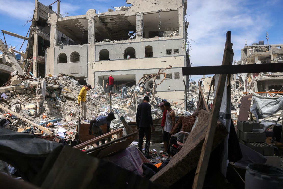 People look for salvageable items in the rubble of a building hit in an Israeli strike in Jabalya in the northern Gaza Strip on May 15, 2025.