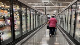 A woman walks in an aisle of a Walmart supermarket in Houston, Texas, on May 15, 2025. Walmart on Thursday reported another solid quarter behind sales gains in the United States, but warned of higher prices and continued uncertainty over President Donald Trump's tariffs.