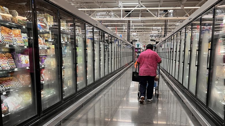 A woman walks in an aisle of a Walmart supermarket in Houston, Texas, on May 15, 2025. Walmart on Thursday reported another solid quarter behind sales gains in the United States, but warned of higher prices and continued uncertainty over President Donald Trump's tariffs.