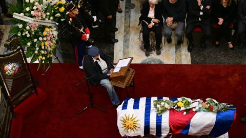 Uruguayan playwright, poet and journalist Mauricio Rosencof (L) reads poems as Uruguay's former vice president and the wife of the late Uruguay's former president (2010-2015) Jose 'Pepe' Mujica, Lucia Topolansky, Uruguay's President Yamandu Orsi (2nd R) and Uruguay's Vice-President Carolina Cosse (R) look on during Mujica's wake at the Palacio Legislativo, in Montevideo, on May 15, 2025. For a second day, thousands of Uruguayans lined up to bid farewell to deceased former leader Jose "Pepe" Mujica, who lost a year-long battle against cancer on May 13, 2025. The 89-year-old erstwhile leftist guerrilla, who spent a dozen years behind bars for revolutionary activity, was famed for his humility and once known as the "world's poorest president". (Photo by Pablo PORCIUNCULA / AFP) (Photo by PABLO PORCIUNCULA/AFP via Getty Images)          