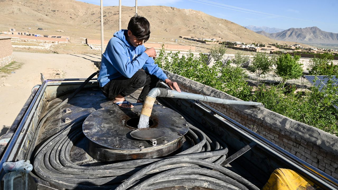 An Afghan boy fills his potable water tanker from a pump on the outskirts of Kabul on April 27, 2025.