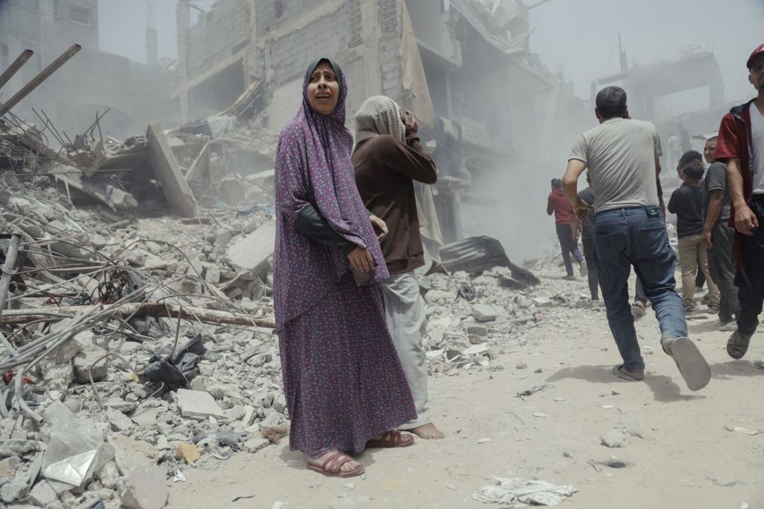 Civiles palestinos caminan entre estructuras derrumbadas y escombros tras un ataque aéreo israelí en Gaza, el sábado.