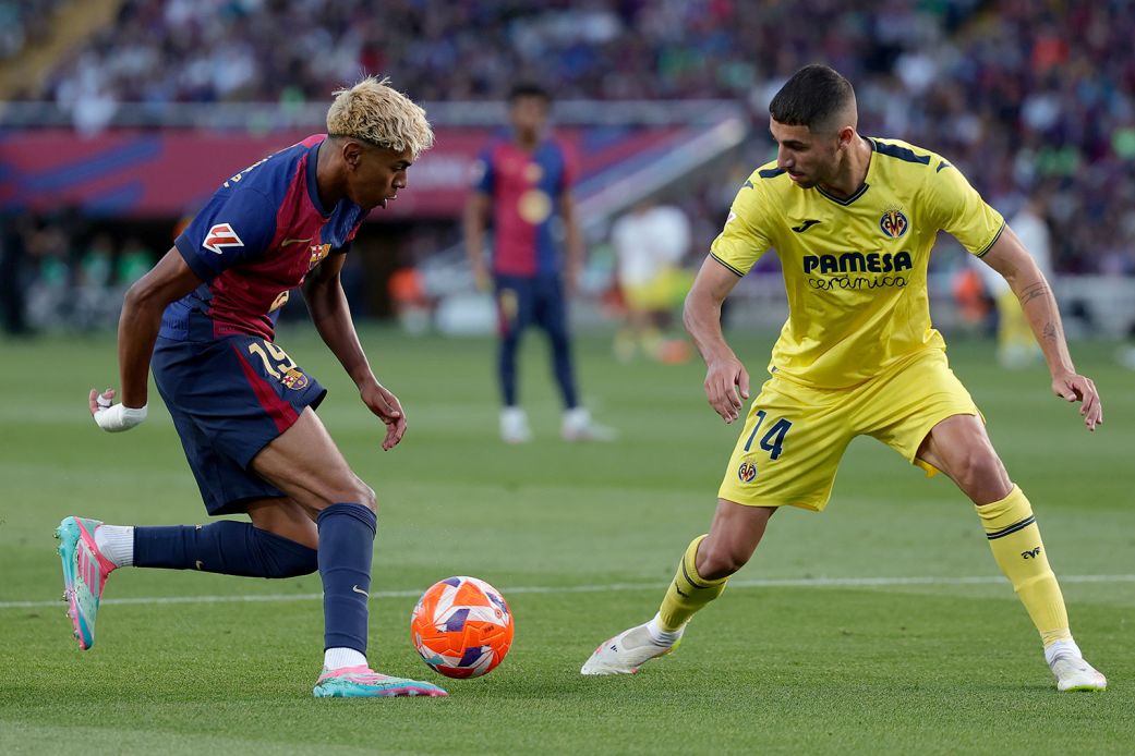 Barcelona's Lamine Yamal dribbles at Villarreal's Santi Comesaña during a match last season.