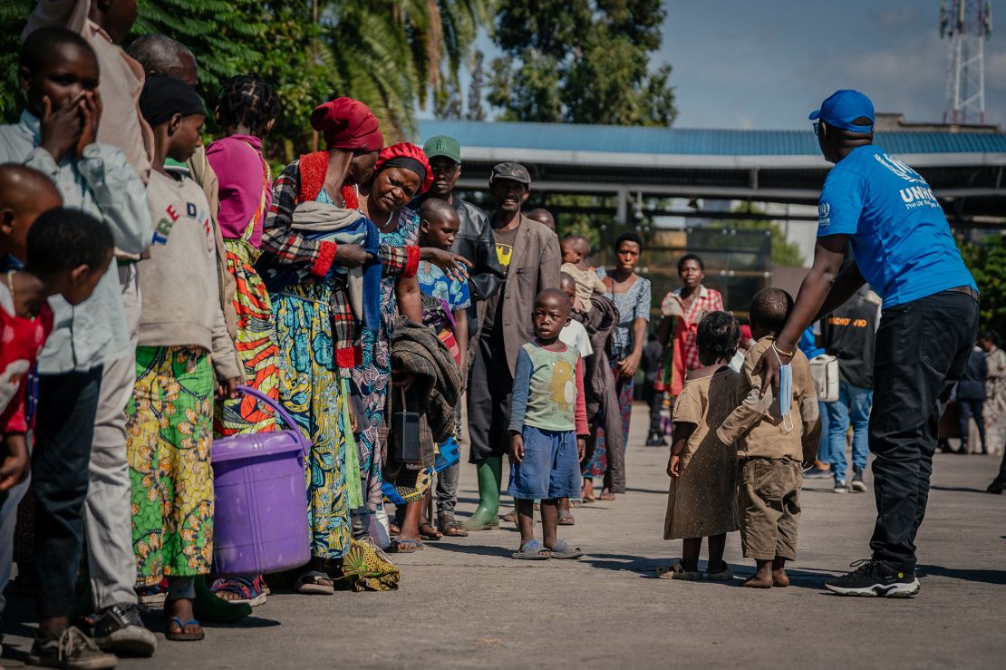 Displaced persons, believed to be Rwandan nationals, stand in line for a check after being dropped off at the border between the Democratic Republic of Congo and Rwanda, in Goma on May 19, 2025.