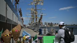 People visit a makeshift memorial as the Mexican Navy training ship that hit the Brooklyn Bridge is moored in Lower Manhattan on May 19, 2025 in New York City. US safety officials launched a probe Sunday after a 150-foot tall Mexican sailing ship crashed into New York's iconic Brooklyn Bridge, snapping its masts and killing two crew . Numerous sailors were positioned among the navy vessel Cuauhtemoc's rigging at the time, video of the incident showed. (Photo by ANGELA WEISS / AFP) (Photo by ANGELA WEISS/AFP via Getty Images)