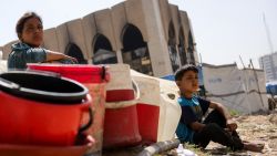 Children sit with plastic buckets as displaced Palestinians collect water in Gaza City, on May 20, 2025, amid the ongoing war between Israel and the Palestinian militant movement Hamas. Israel, pressing a newly expanded military offensive across the Gaza Strip, has faced mounting pressure including from key backer the United States to end the aid blockade it imposed on March 2. (Photo by Bashar TALEB / AFP) (Photo by BASHAR TALEB/AFP via Getty Images)