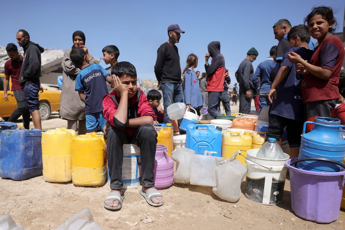 People wait to see if they can collect water at a camp for displaced people in Gaza City, on May 20, 2025.
