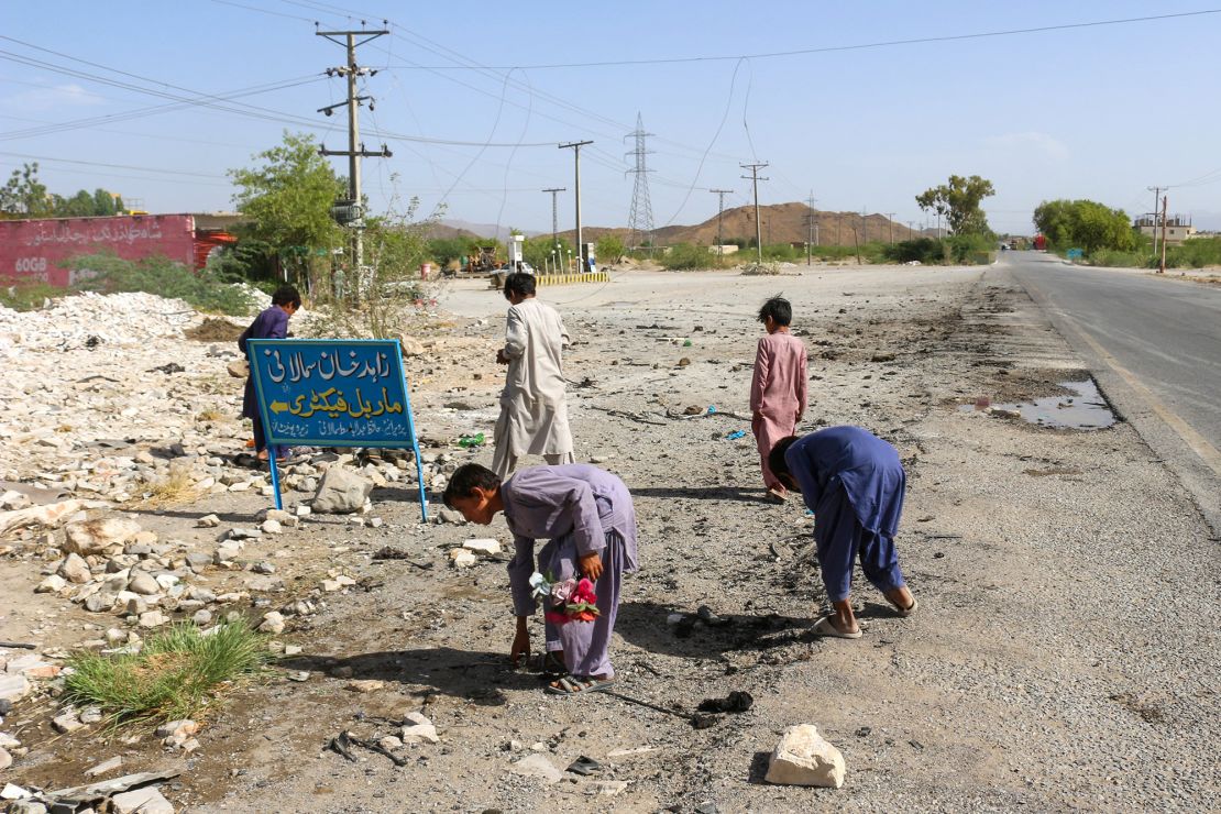 Local boys inspect site of a school bus bombing in Khuzdar district of Balochistan province, Pakistan, on Wednesday.