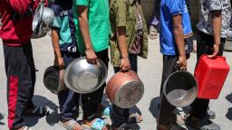 Palestinos se reúnen para recibir una comida caliente en un punto de distribución de alimentos en el campamento de refugiados de Nuseirat, en el centro del enclave de Gaza, el 21 de mayo de 2025. Los gazatíes esperaban desesperadamente suministros vitales el 21 de mayo después de que Israel anunciara que había permitido la entrada de docenas de camiones de la ONU, pero se enfrentaba a una creciente presión internacional para aumentar el flujo de ayuda y abandonar su intensificada campaña militar.