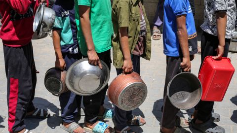 Palestinos se reúnen para recibir una comida caliente en un punto de distribución de alimentos en el campamento de refugiados de Nuseirat, en el centro del enclave de Gaza, el 21 de mayo de 2025. Los gazatíes esperaban desesperadamente suministros vitales el 21 de mayo después de que Israel anunciara que había permitido la entrada de docenas de camiones de la ONU, pero se enfrentaba a una creciente presión internacional para aumentar el flujo de ayuda y abandonar su intensificada campaña militar.