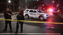 police officers standing in front of a police car on a city street